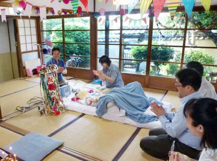 Misato Komiyama, a quadriplegic, celebrates her birthday with family members and volunteers at the boardinghouse. From kyodonews.net