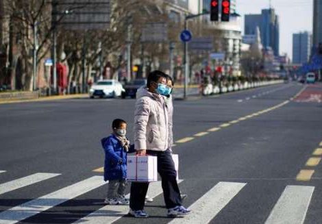 A family crosses a street in empty downtown Shanghai. From reuters.com