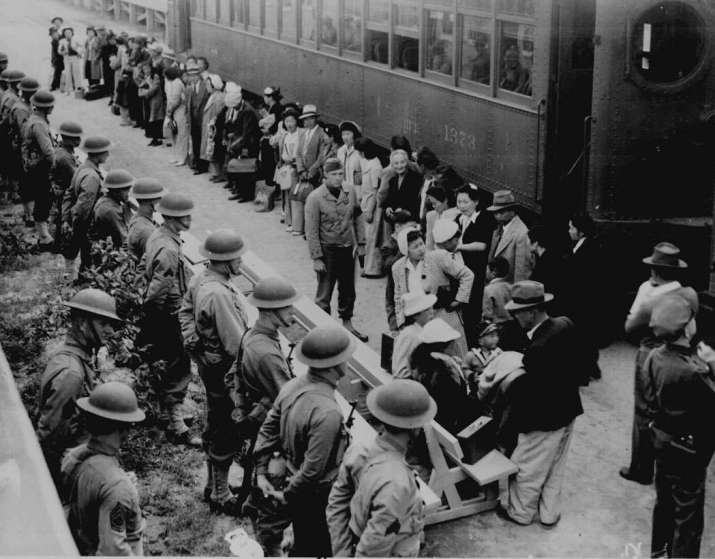 Japanese Americans arrive at the Santa Anita Assembly Center from San Pedro, 1942. Evacuees lived at this center at the former Santa Anita race track before being moved inland to relocation centers. From archives.gov