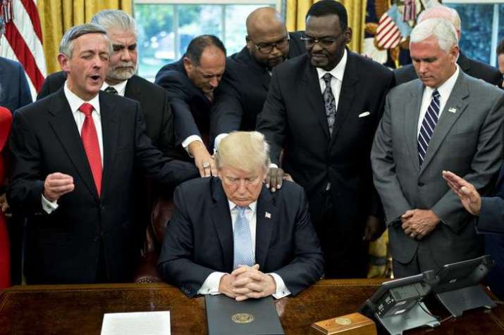 Evangelical leaders hold a prayer for Trump and Mike Pence, far right, at the White House in September 2017. From newyorker.com
