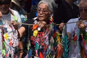 Satsuki Ina, 75, hangs origami cranes as part of the Tsuru for Solidarity protest of child detention at Fort Sill on 22 June. From nhregister.com