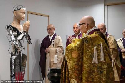 A Buddhist priest bows to the android Kannon Bodhisattva during the unveiling ceremony before its first sermon. From dailymail.co.uk