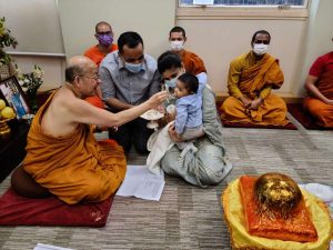 Ven. Dhammajoti feeds Tijil Barua Troy his first solid food. Photo by the author