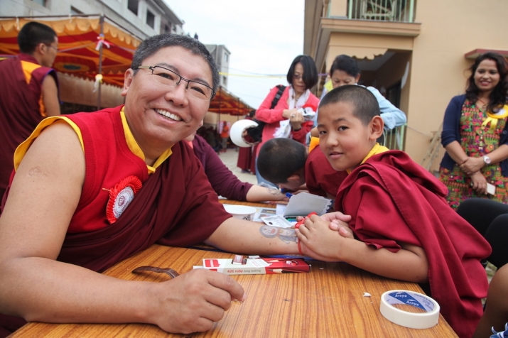 Rinpoche visits Class 3's body-painting stall at a school expo. Image courtesy of Tsoknyi Gechak School