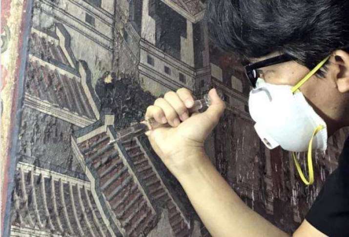 Glue is injected to consolidate the fragile paint. Photo Courtesy of the Fine Arts Department. From bangkokpost.com