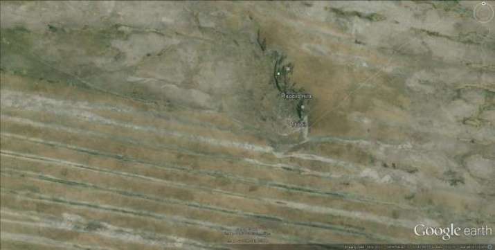 Arial image of the Tsodilo Hills with surrounding erosion patterns that seem to be irrigation canals, about a mile apart. From ancientmistery.weebly.com