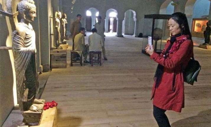 A Chinese academic takes a picture during the Peshawar Museum visit. From dawn.com