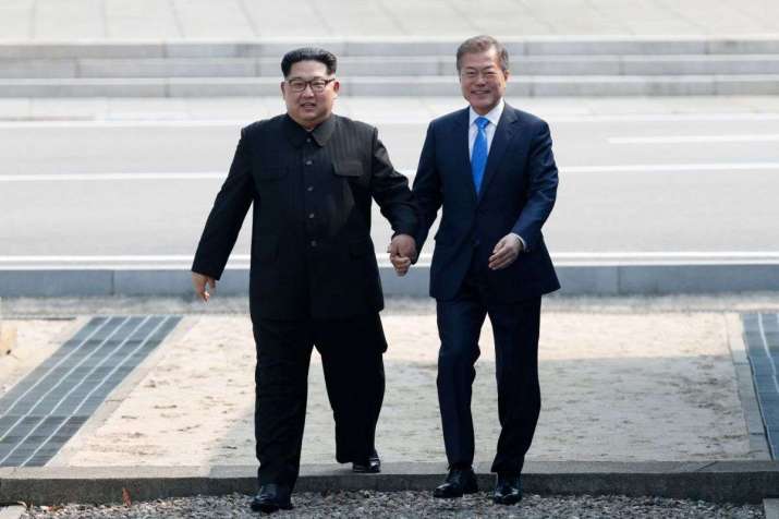 North Korean leader Kim Jong-un, left, and South Korean president Moon Jae-in walk across the military demarcation line at Panmunjom on 27 April. From straitstimes.com
