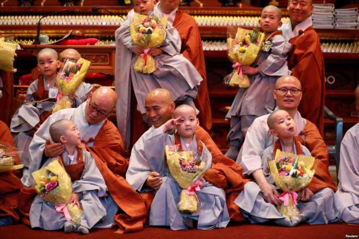 Temporarily ordained novice monks pose for photographs at Jogye-sa in Seoul. From voanews.com