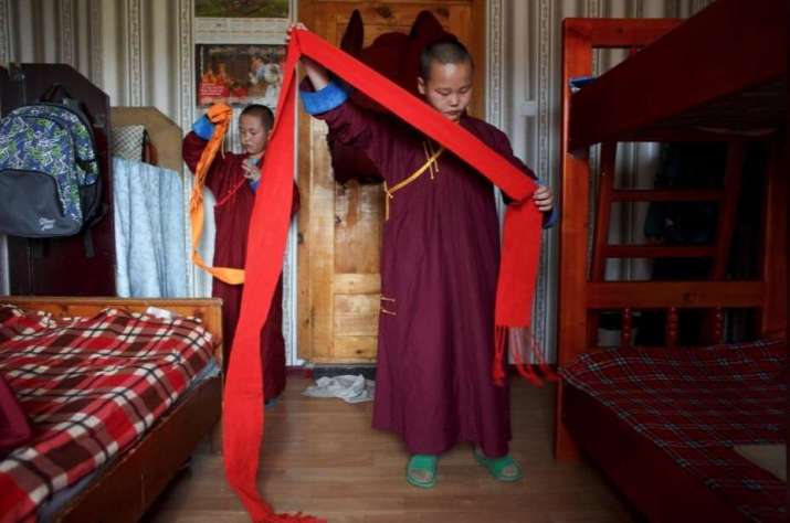 Novice monk Temuulen and his roommate get dressed for another day at Amarbayasgalant Monastery. Photo by Thomas Peter. From reuters.com