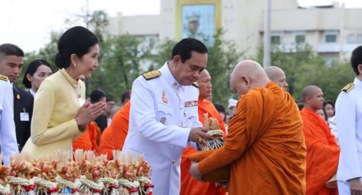 Thai Prime Minister Prayuth Chan-o-cha gives alms to a Buddhist monk to celebrate the birthday of the king. From nationmultimedia.com