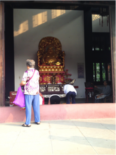 Lay Buddhists bowing to the laughing Buddha in Fosheng Si, Sichuan Province. Image courtesy of the author