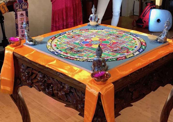 Completed sand mandala embellished with buddhas, flowers, candles, and <i>khata</i> scarves. Photo by the author