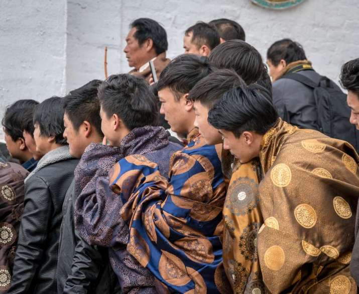 2018. Wu Village Lower Monastery. Young men stand very close together at a good viewing spot for the Cham. It was one of the more exciting times during the Cham when the deity was getting close to defeating the evil spirits, so everyone wanted to see the action.