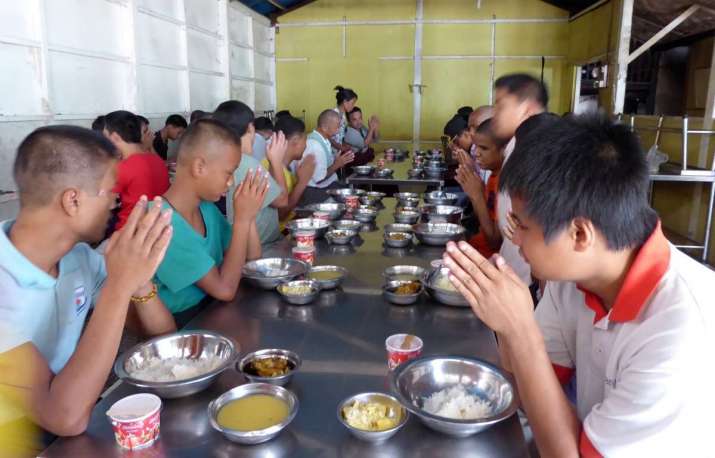 Students observe Buddhist rituals before meal times