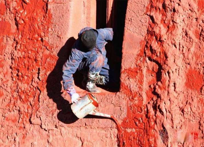 A worker applied a fresh coat of colored wash to the walls of the Red Palace. From chinadaily.com.cn
