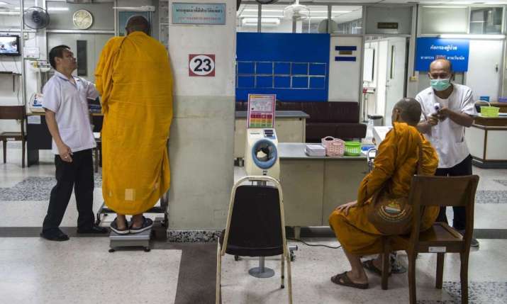 Nurses attend to patients at a government-run hospital for Buddhist monks in Bangkok. Photo by Romeo Gacad. From theguardian.com