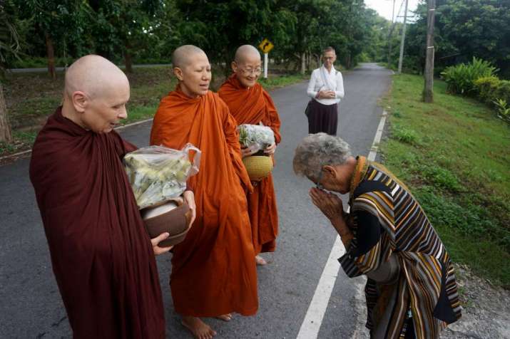 Female monastics receive food during their morning alms round. From asia.nikkei.com