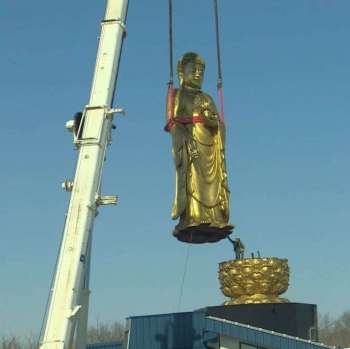 Two cranes lift the 15-metre statue onto its base. From cbc.ca
