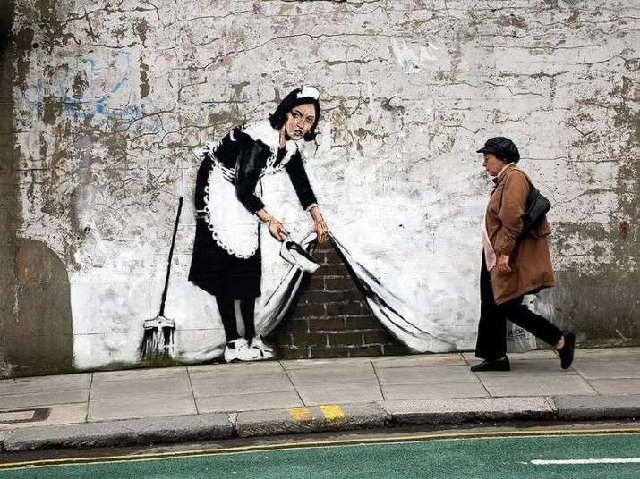 <i>Sweeping It Under the Carpet</i> by Banksy. From cntraveler.com