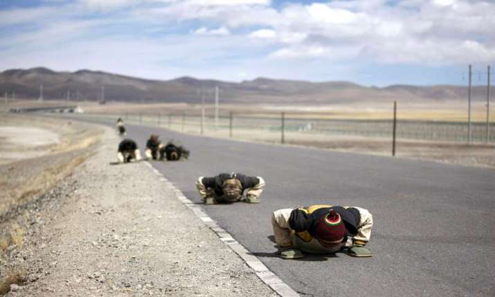 Tibetan Buddhist pilgrims prostrate themselves along a road during their journey to Lhasa. From chinadaily.com.cn