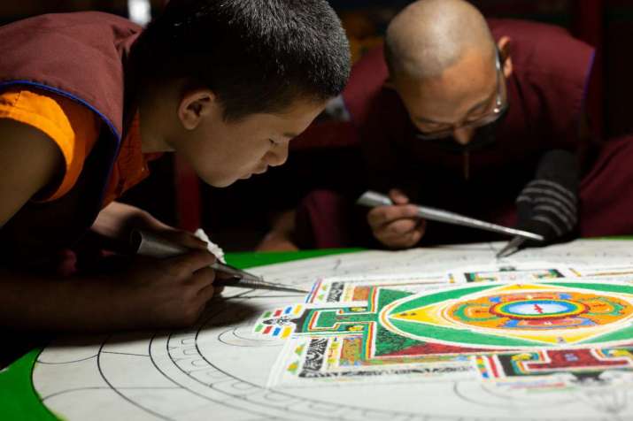A young monk learning sand mandala technique, a skill that requires intense concentration, at work on the mandala to be used in a Mani recitation ritual. Photo copyright Jonathan Greet, 2019, for Core of Culture