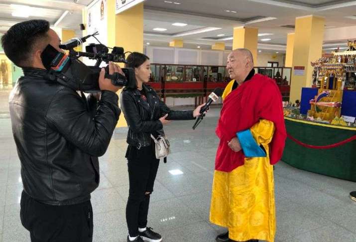 Khamba Lama Gabju speaks to a reporter about the conclave and exhibits on 7 September. Photo by the author