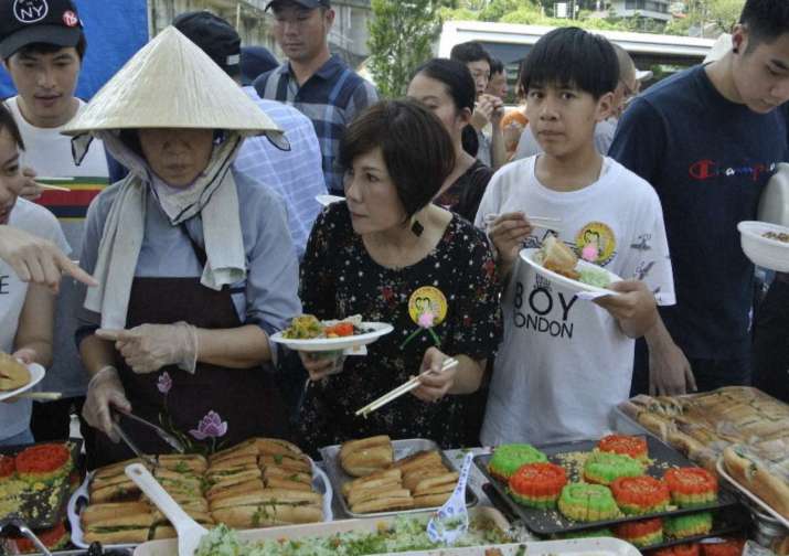 Vietnamese Buddhists at the temple line up for a buffet lunch. From mainichi.jp