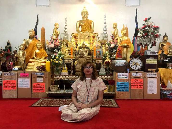 Meditation teacher Arunee Price sitting in front of Buddhist iconography at the temple in 2017. From reviewjournal.com