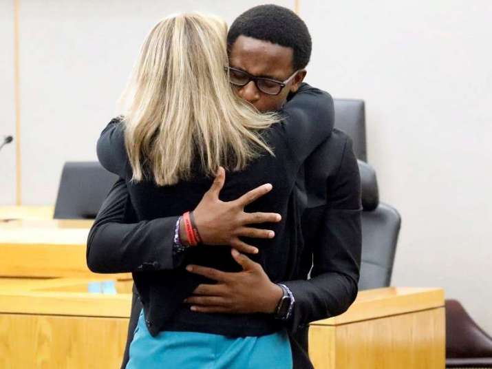Brandt Jean embraces Amber Guyger, the white police officer who shot and killed his brother. From npr.org