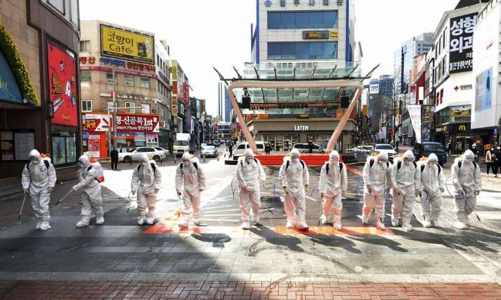 Soldiers spray disinfectant in Daegu, a stronghold of the Shincheonji Church linked to a large number of virus infections in South Korea. Photo by Lee Moo-ryul. From theguardian.com