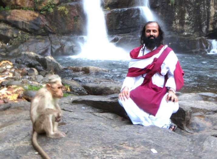 Prabodha Jnana meditating near a cave in the forest at Courtallam (Kuttalam), Tamil Nadu. Image courtesy of Prabodha Jnana and Abhaya Devi