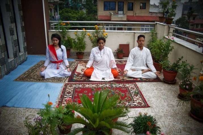 A Nepalese family perform yoga at their home in Kathmandu during the International Day of Yoga. Photo by Sulav Shrestha. From xinhuanet.com