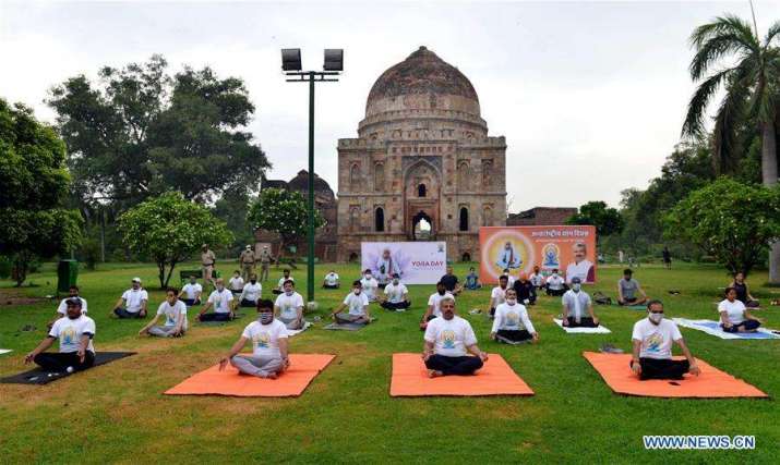 People perform yoga in the Lodhi garden in New Delhi. Photo by Partha Sarkar. From xinhuanet.com
