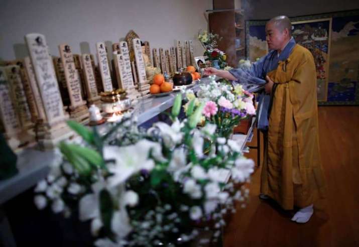 Vietnamese Buddhist nun Thich Tam Tri offers incense at an altar in Nissinkutu. Before her are rows of wooden tablets bearing the names of Vietnamese students and workers who died in Japan. From japantimes.co.jp