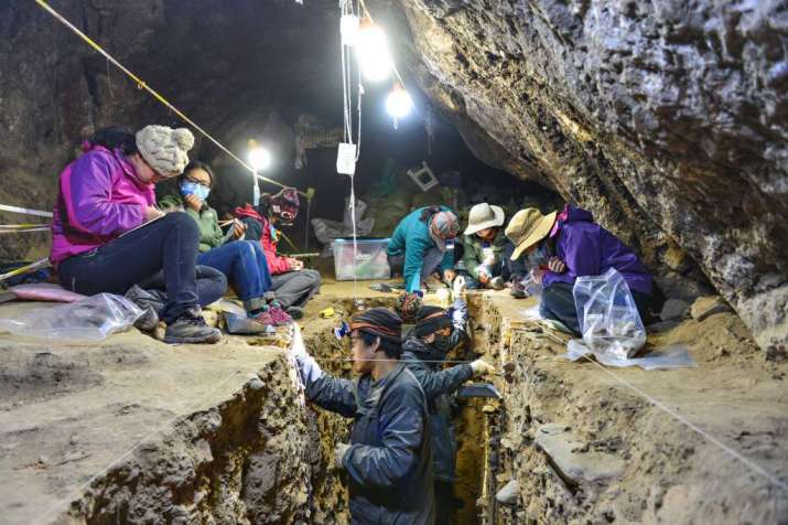 Researchers excavate a section of the Buddhist cave. From smh.com.au
